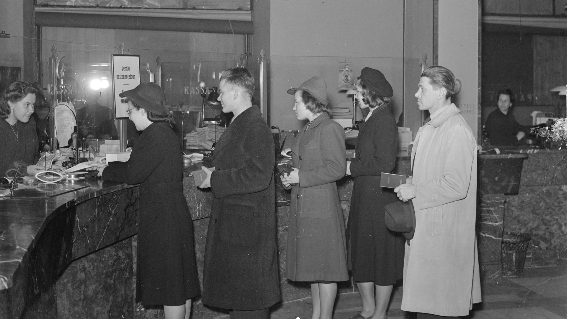 Customers are queuing to bank counter with passbooks to pay taxes. Photo taken in Helsinki, Finland on 3.1.1943.