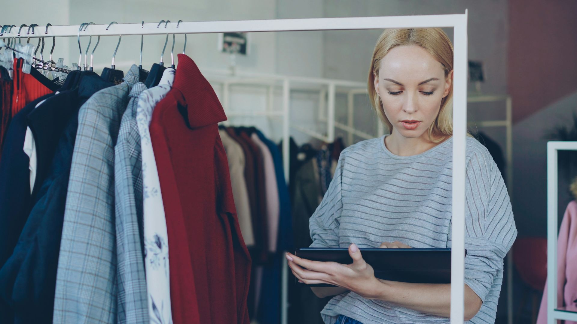 Woman reviews garments in clothing store
