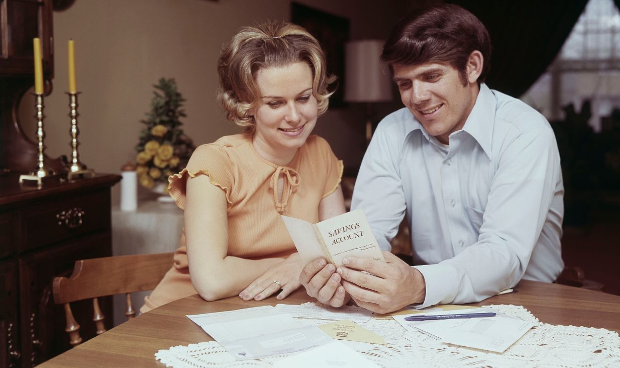 Couple Looking At Banking Savings Passbook At Home
