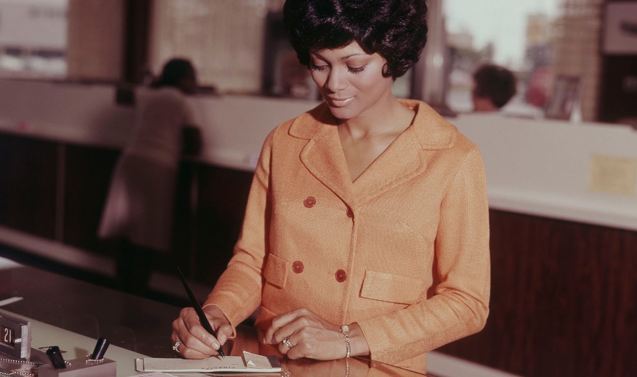 Woman Writing Check In Bank