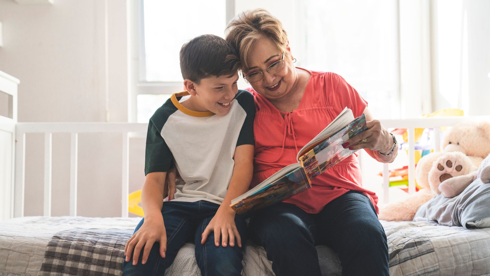 A loving grandmother and her grandson enjoy reading a book together at home.