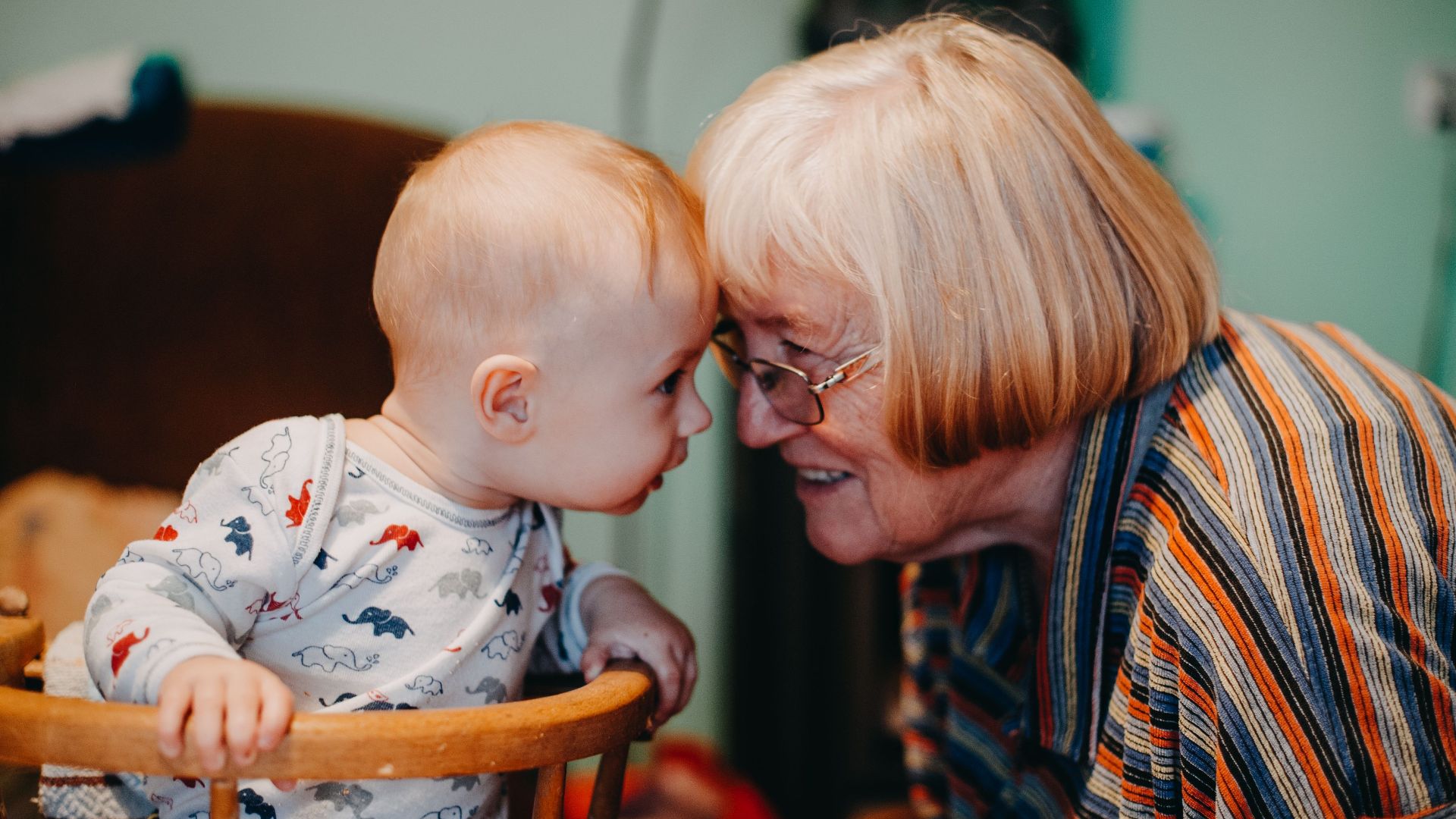 A touching moment shared between a baby and grandmother indoors.