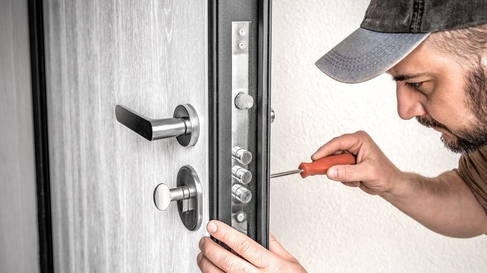 Professional locksmith repairing a door