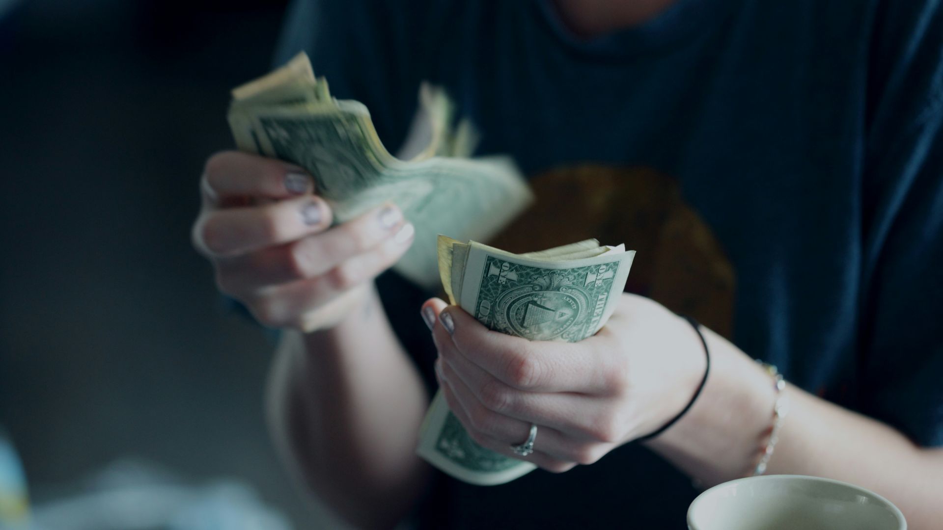 focus photography of person counting dollar banknotes