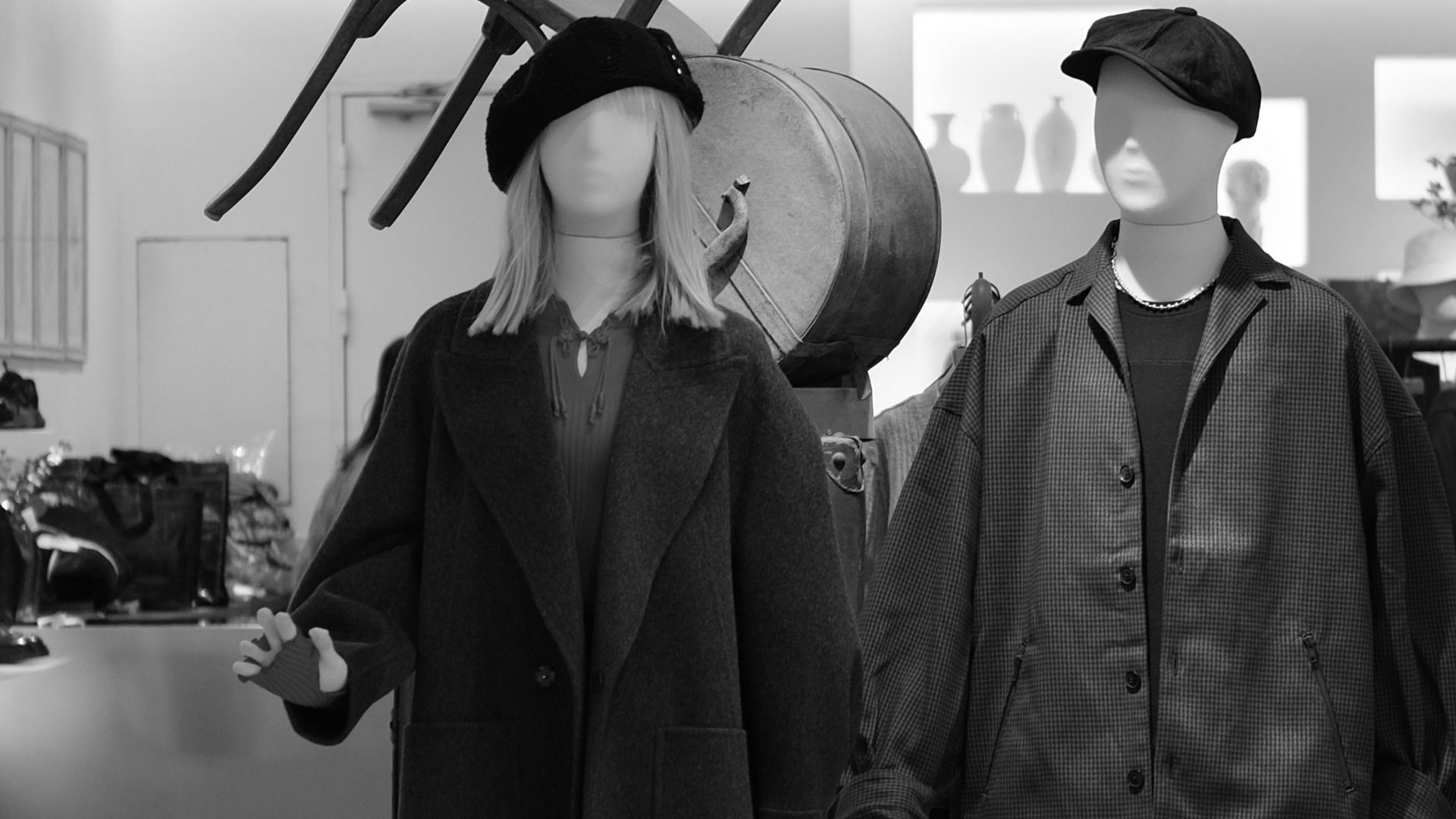 Stylish mannequins in a modern boutique showcasing fashion in a monochrome setting.