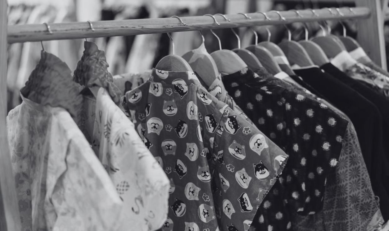 Vibrant clothes hanging on a wooden rack in a boutique shop