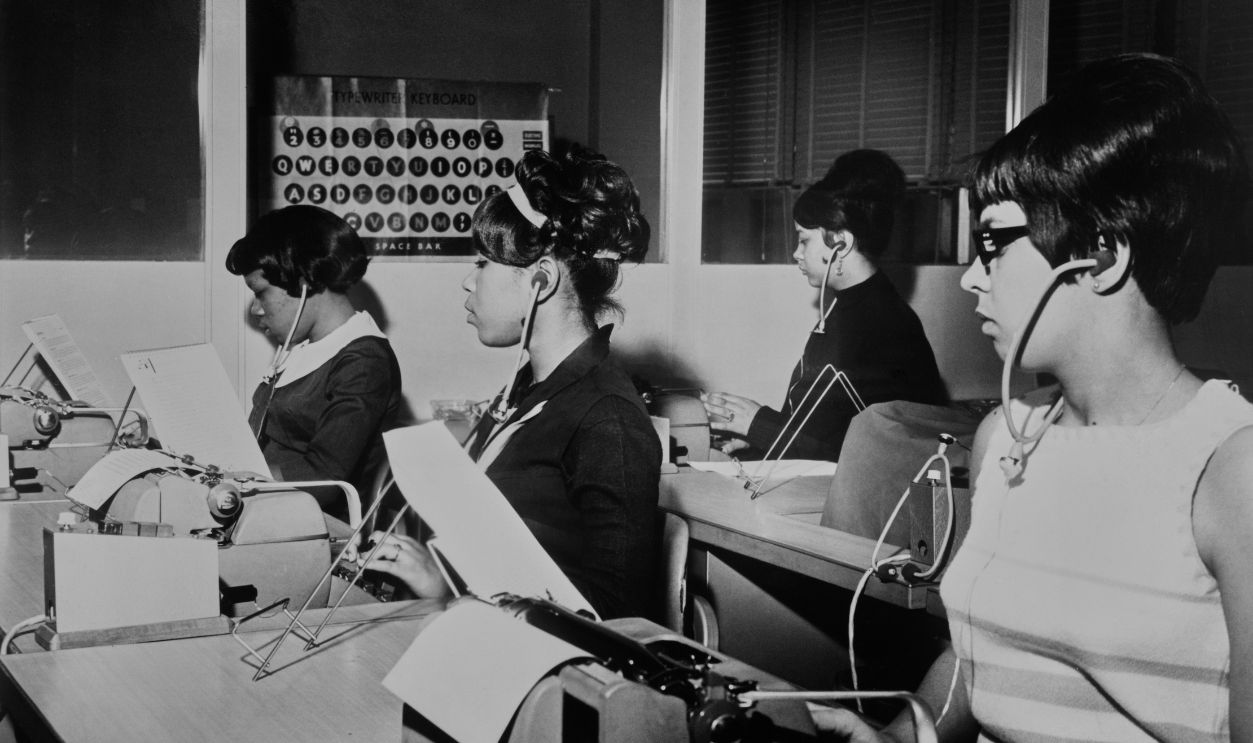 Students using modern audio teaching equipment and teaching materials to learn to increase their typing speed, at the Chemical Bank New York Trust Company training center in New York City, New York, circa 1965. The quick training concept was developed by the National Association of Manufacturers as part of its MIND (Methods of Intellectual Development) program.