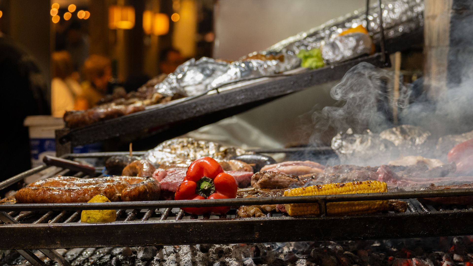 Delicious asado meats and vegetables sizzling on an open grill in Montevideo market.