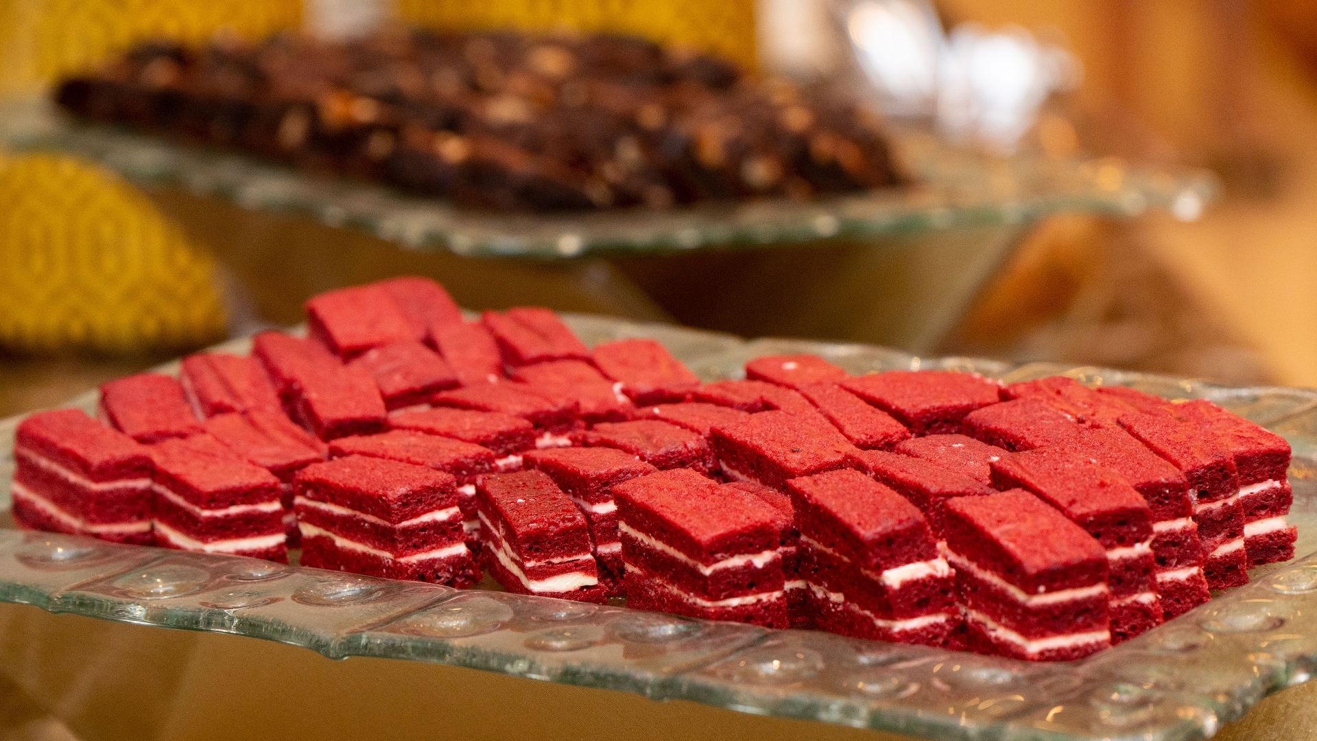 Tempting red velvet layered pastries arranged neatly on a glass platter, perfect for dessert lovers.