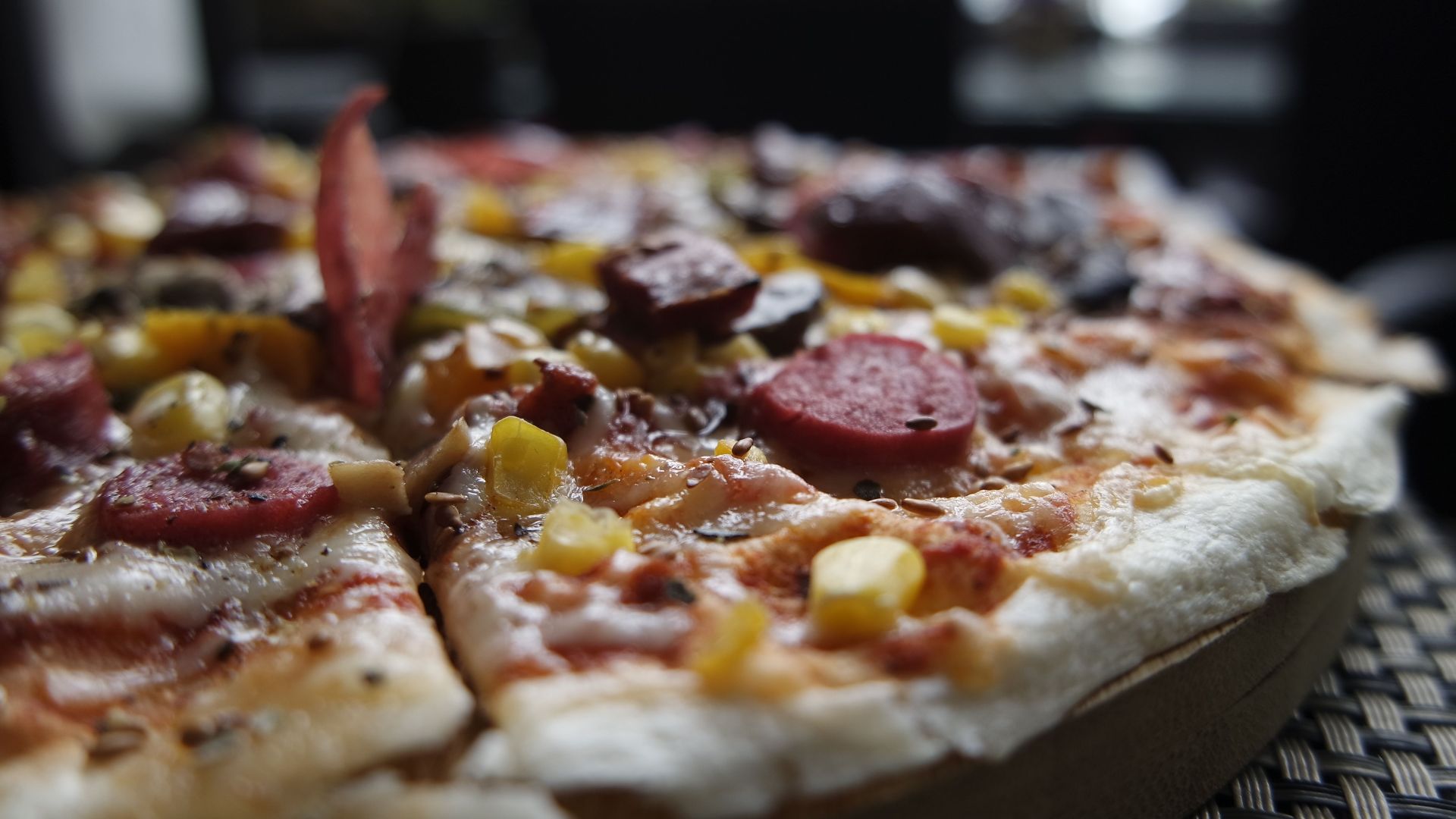 Close-up of a delicious pizza topped with pepperoni, cheese, and vegetables in a cozy Istanbul restaurant.