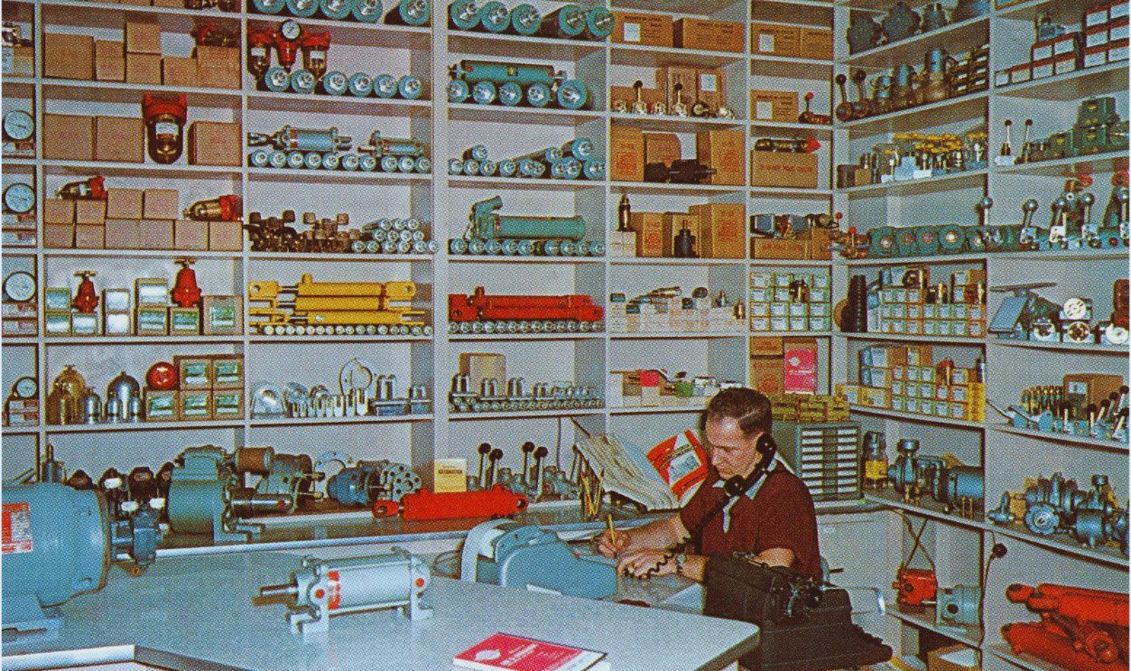 A man on the telephone taking orders at the machine shop