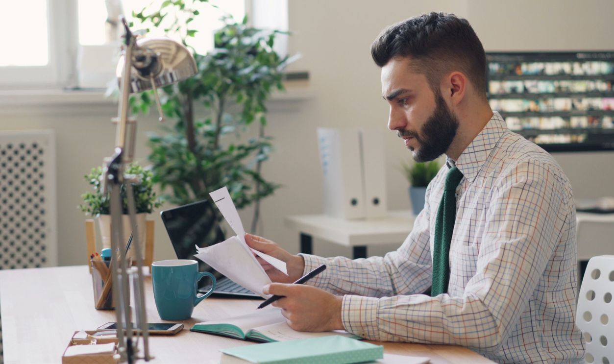 Focused man reviewing documents at a modern office desk