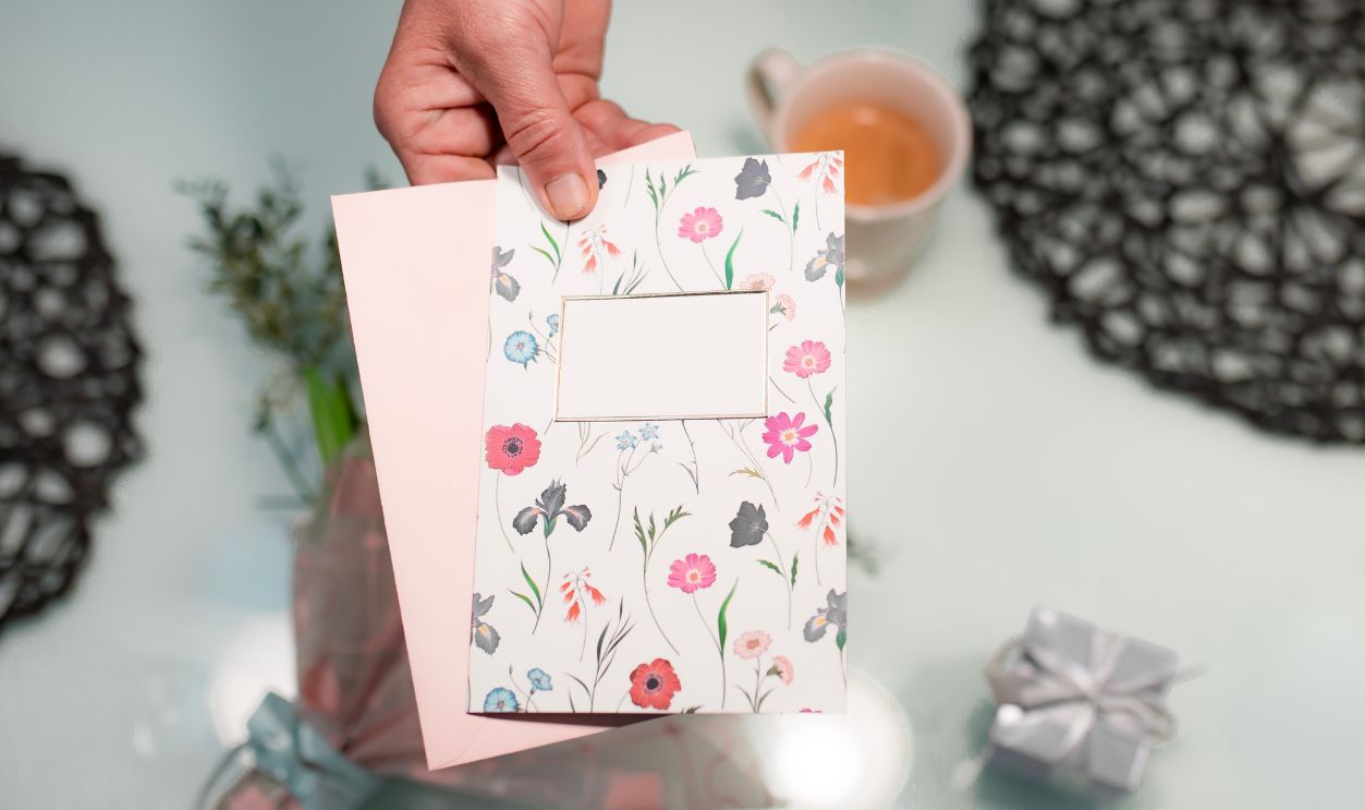 A young person gives a greeting card to an older person