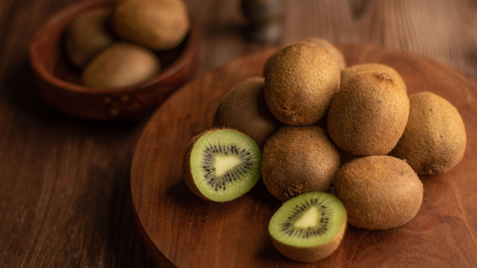 Close-up of organic kiwis on a wooden tray, showcasing the fresh and nutritious fruit.