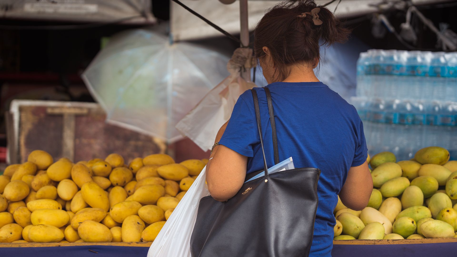 A woman buying fresh mangoes at a local market in Cebu City, Philippines.