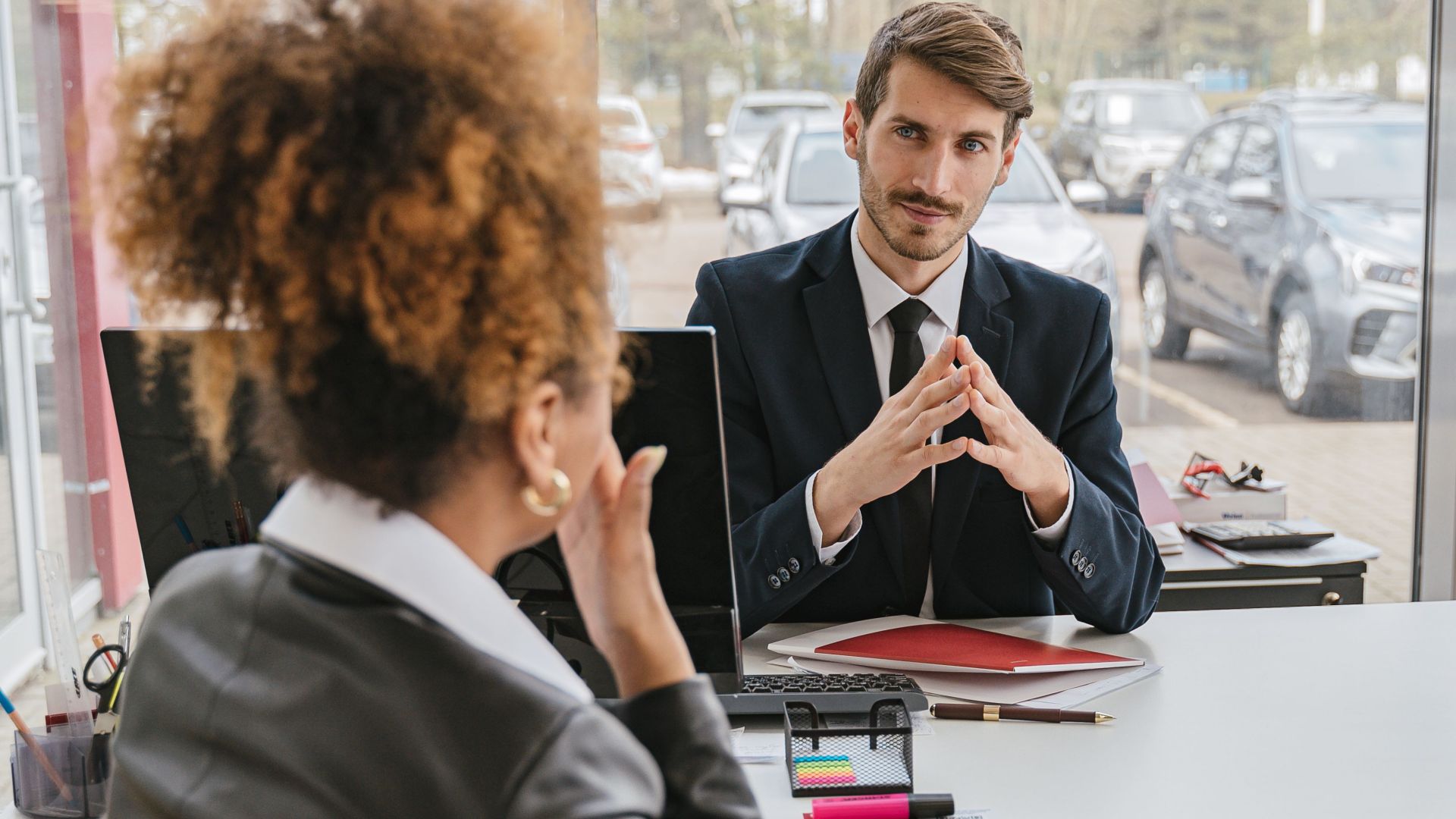 Business professionals engaged in conversation at a modern office desk, discussing ideas and strategies.