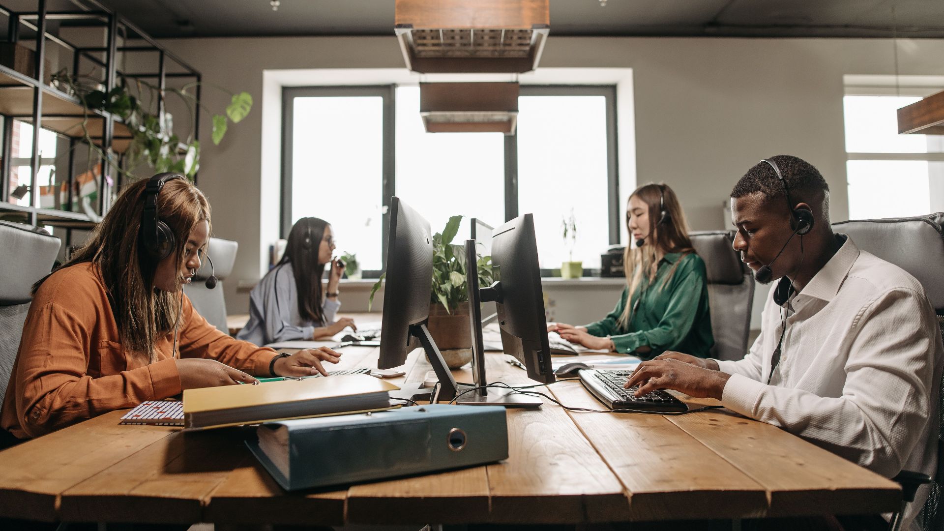A diverse group of employees collaborating with headsets in a modern office setting.