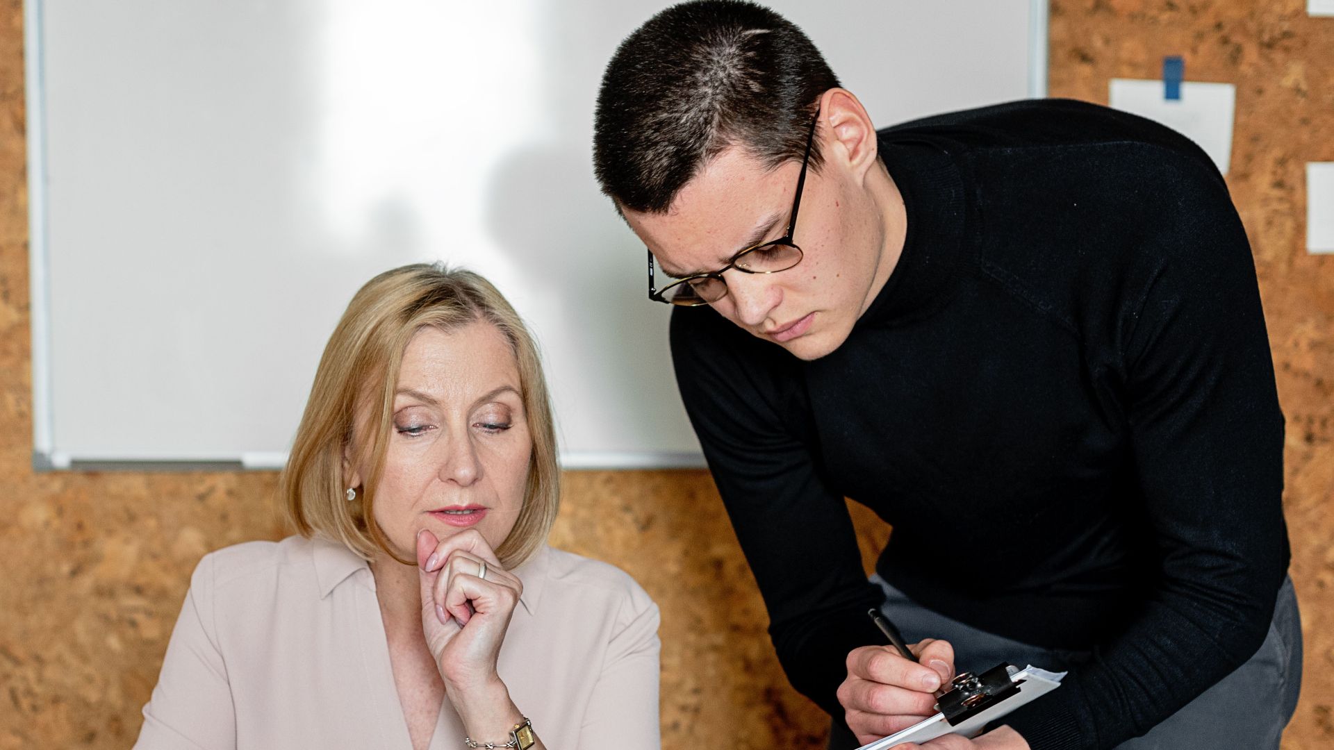 Two colleagues collaborating during a business meeting, focused on planning and communication.