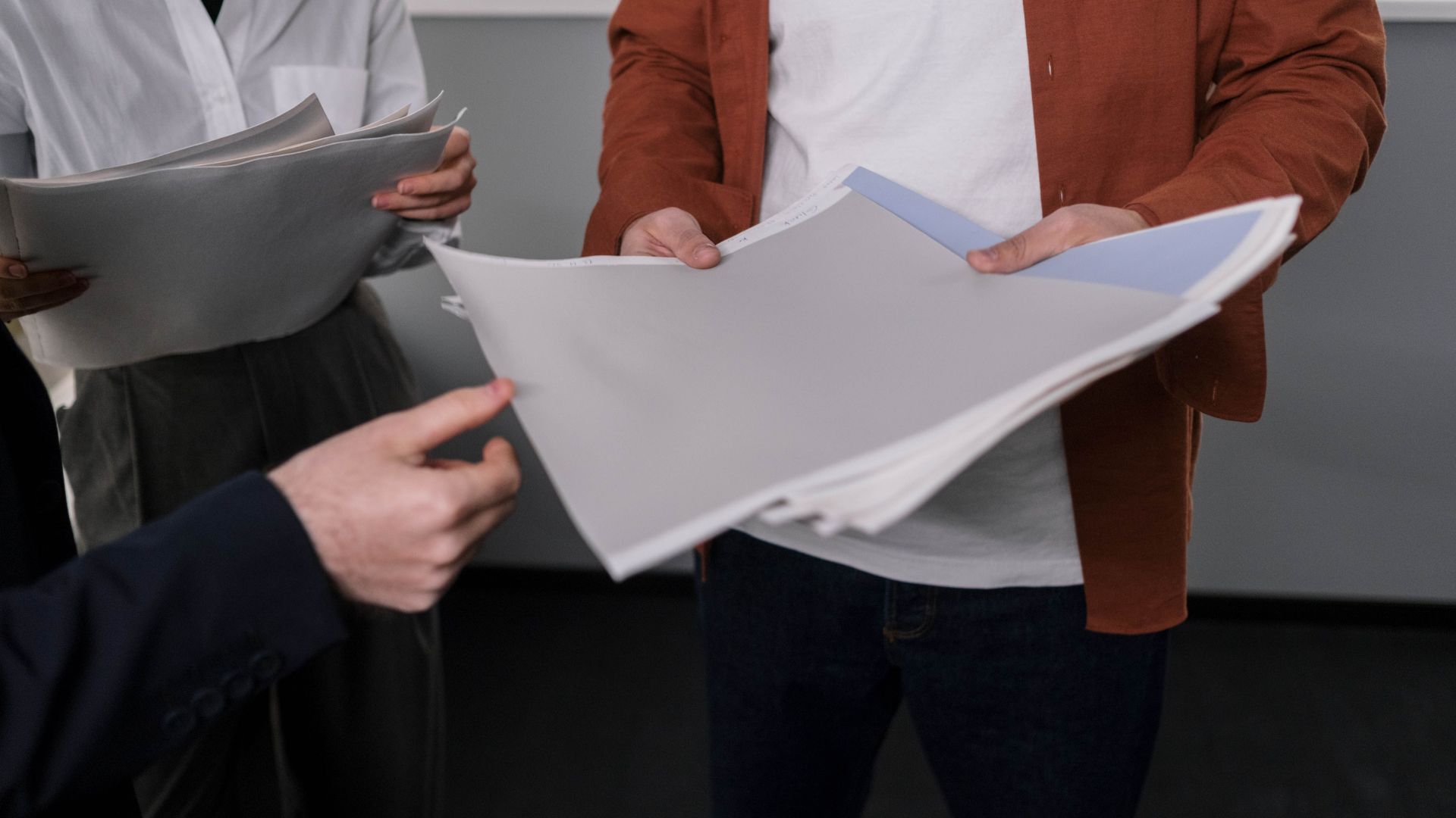 Business professionals discussing interior design samples during a project meeting.