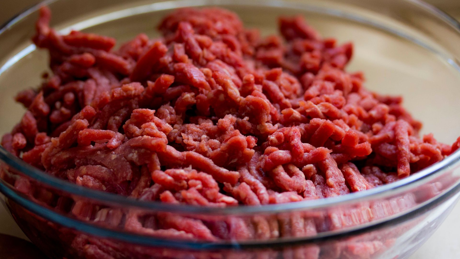High-quality image of fresh ground beef in a glass bowl, ideal for culinary and food-related themes.