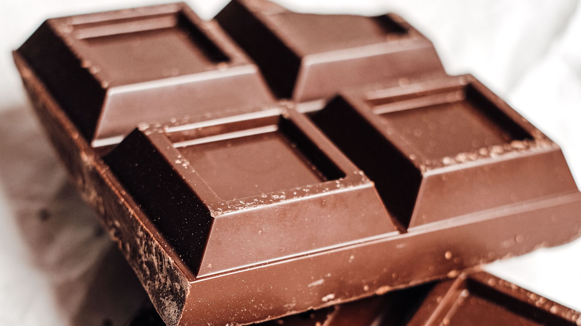 Close-up of tasty chocolate bars stacked on a white background.
