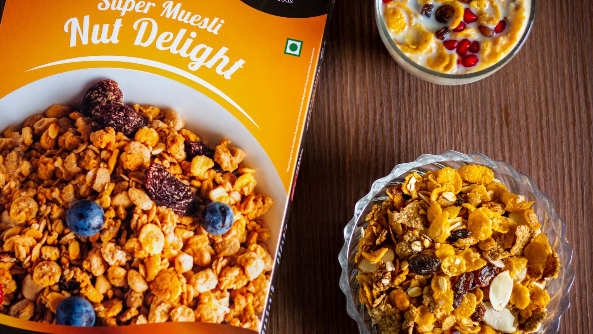 Top view of delicious nut delight muesli with fresh fruits in glass bowls on a wooden table.