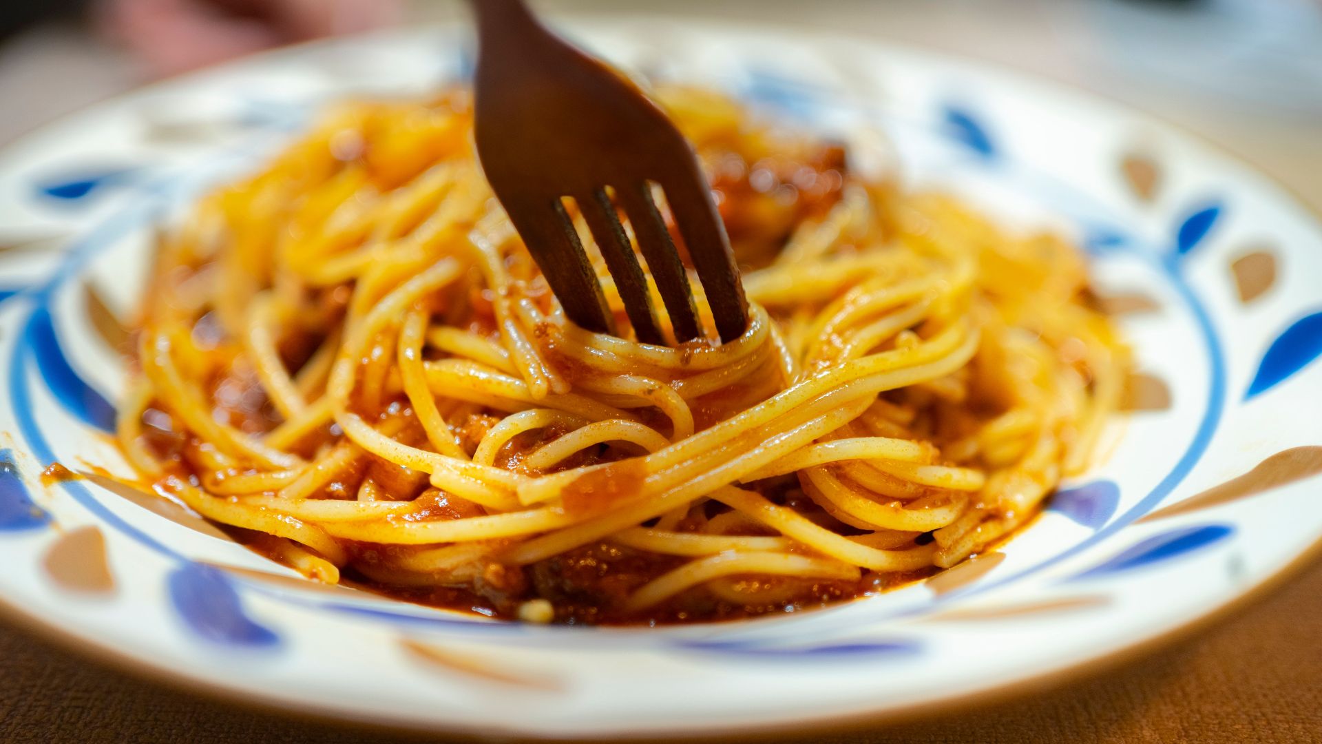 Delicious spaghetti with rich tomato sauce served on an artistic plate, fork ready to dig in.