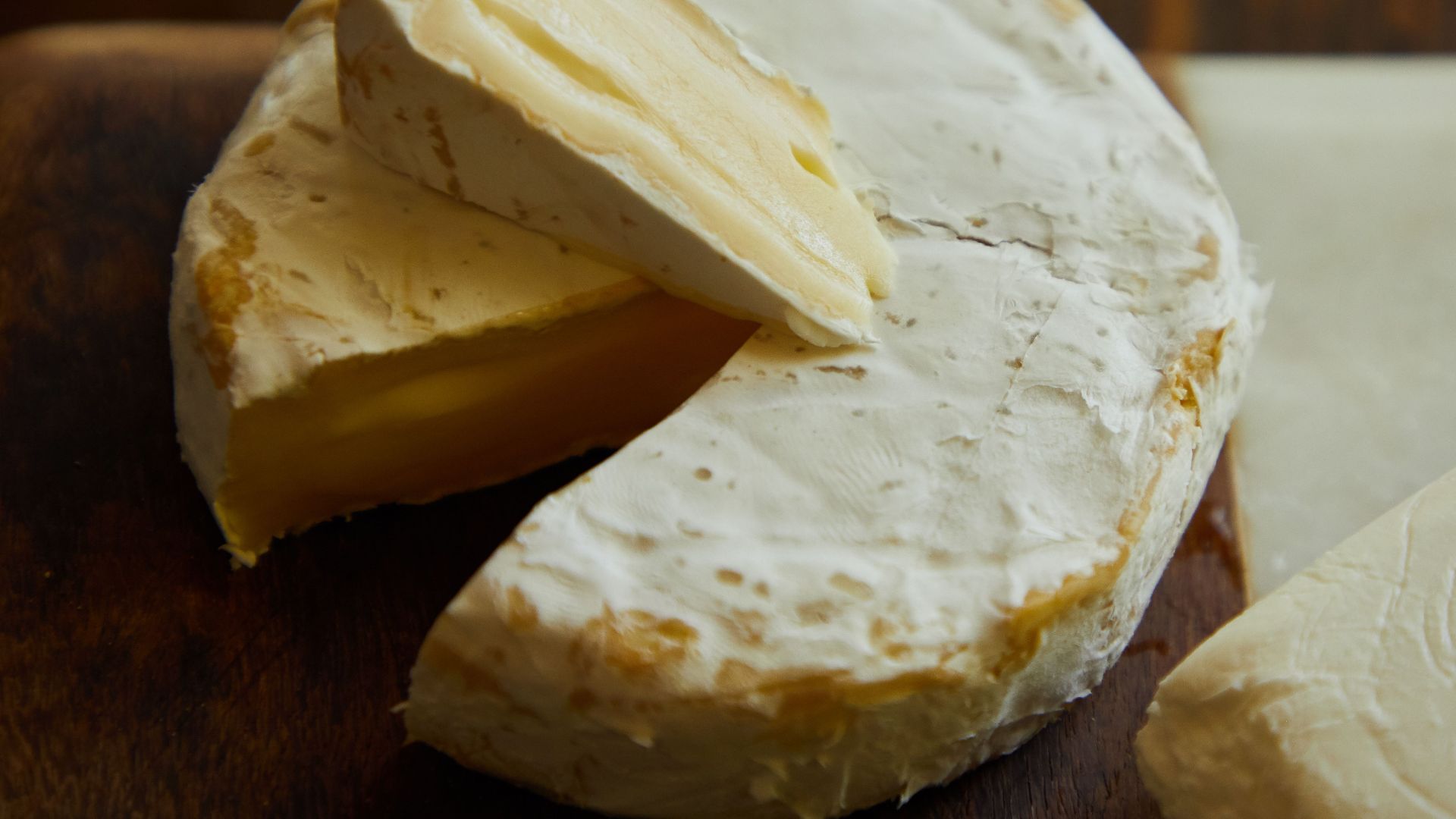 Delicious Camembert cheese wheel and slice showing creamy texture.