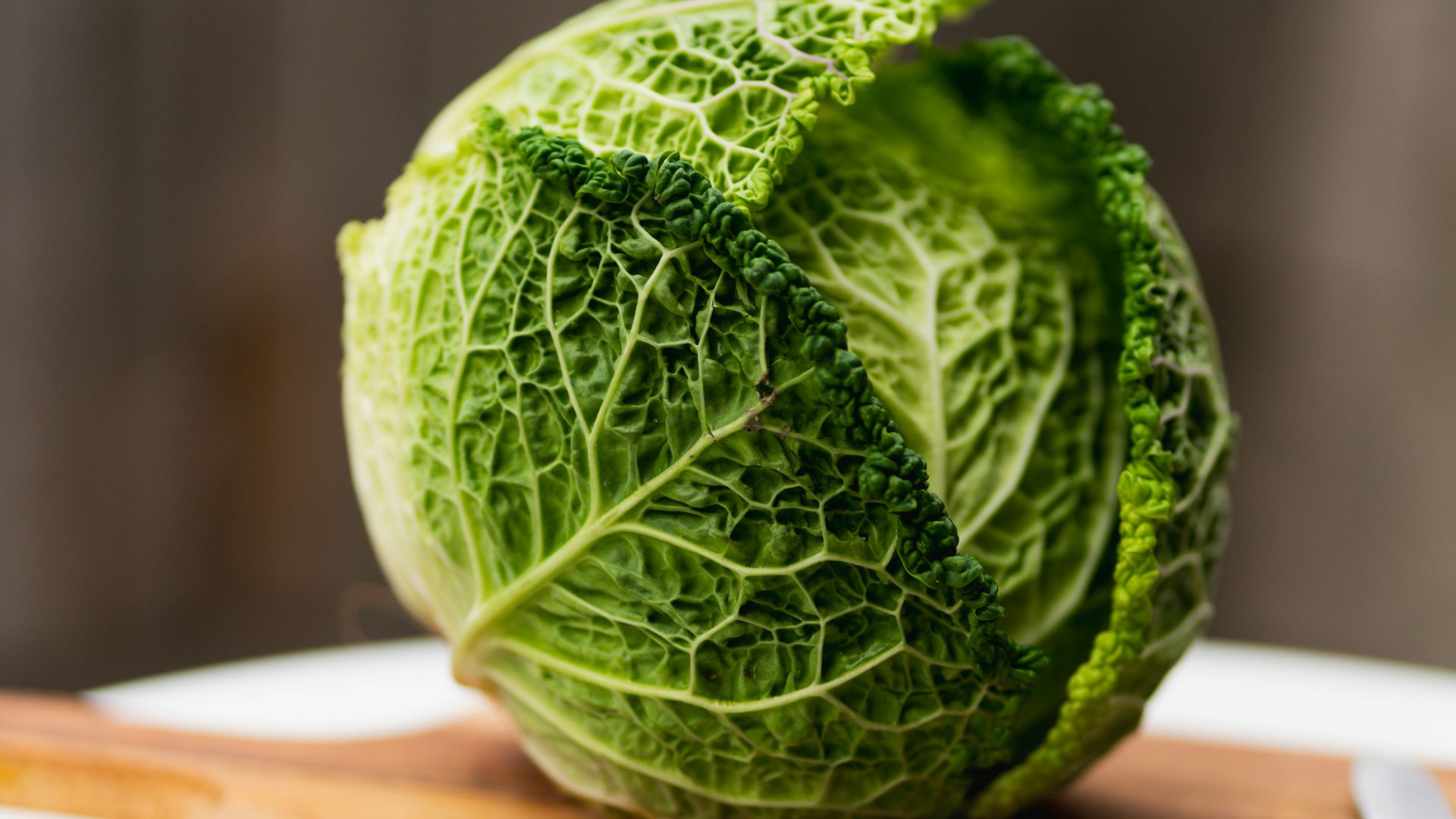 a head of cabbage on a cutting board with a knife