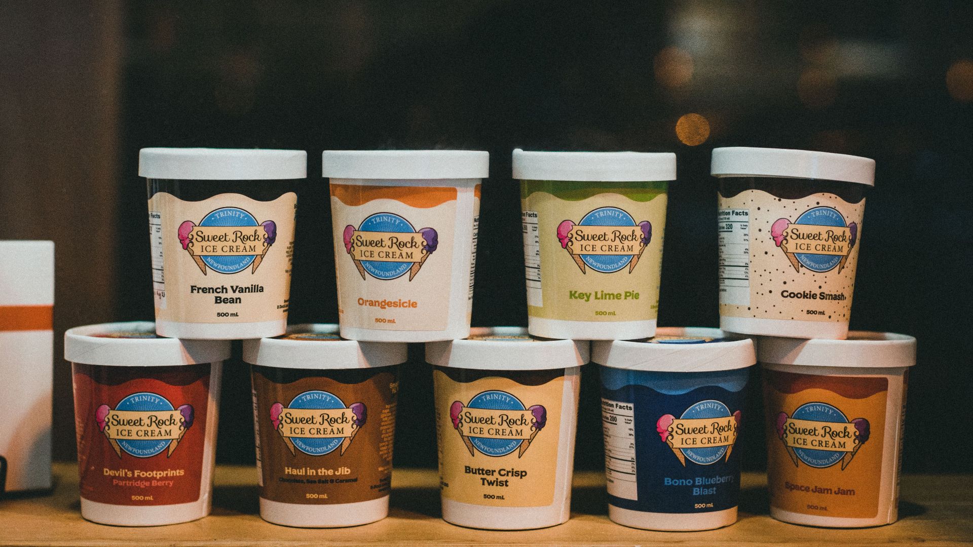 Various Sweet Rock ice cream flavors in branded containers displayed in a stack.