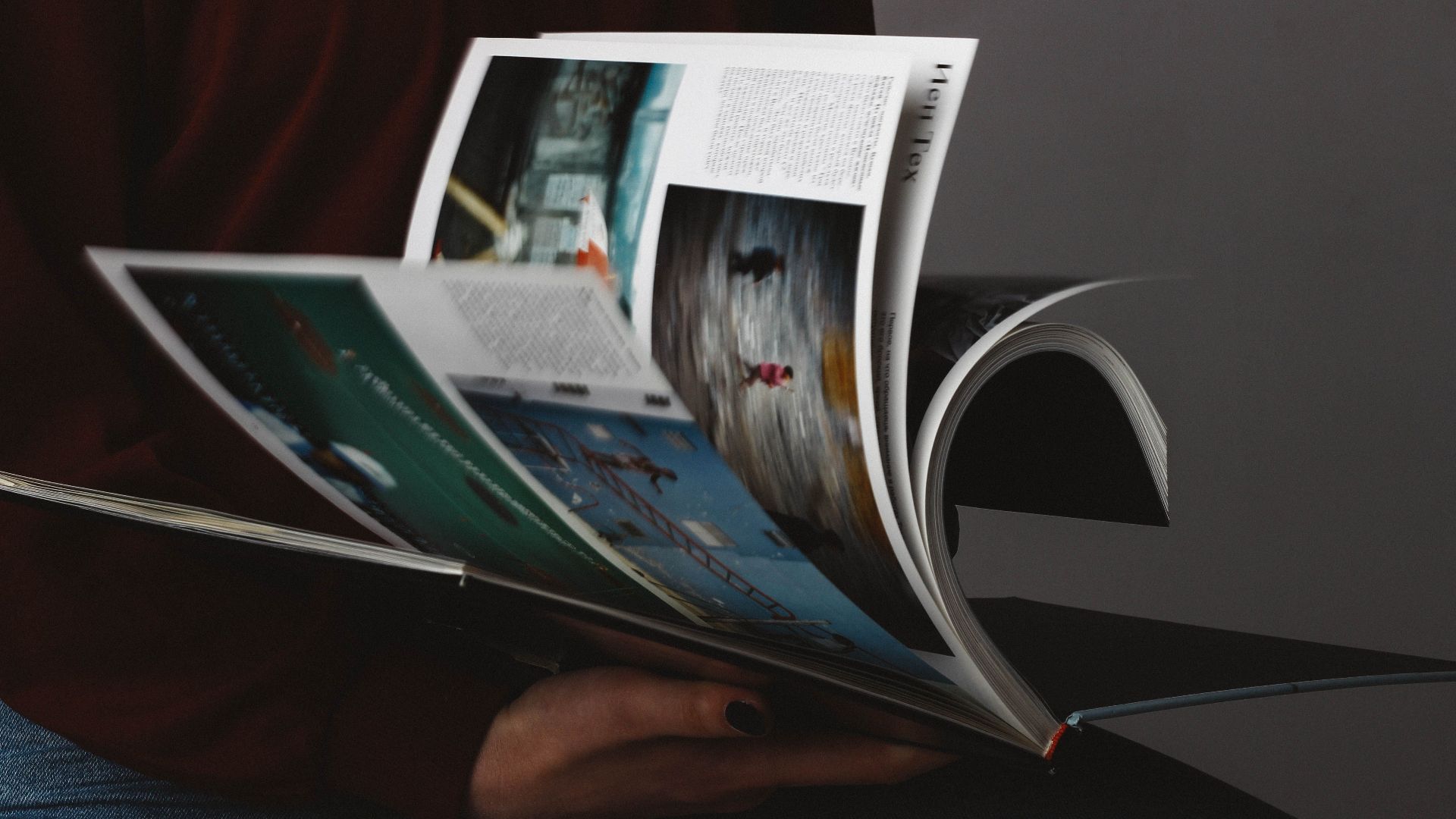 A person flips through a photography book, emphasizing the visuals.