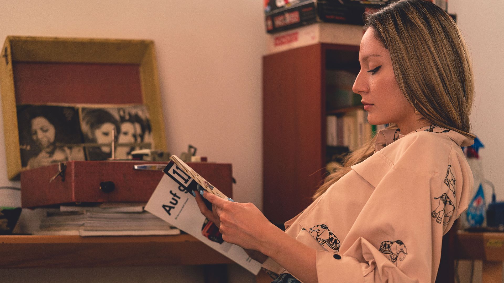 A woman relaxes at home reading a magazine in a vintage-inspired room.