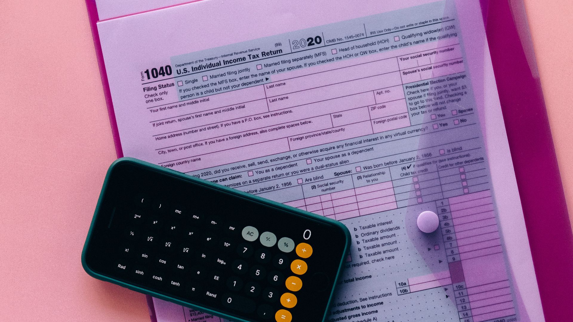 Tax form 1040 with a calculator on a pink background, highlighting finance and accounting themes.