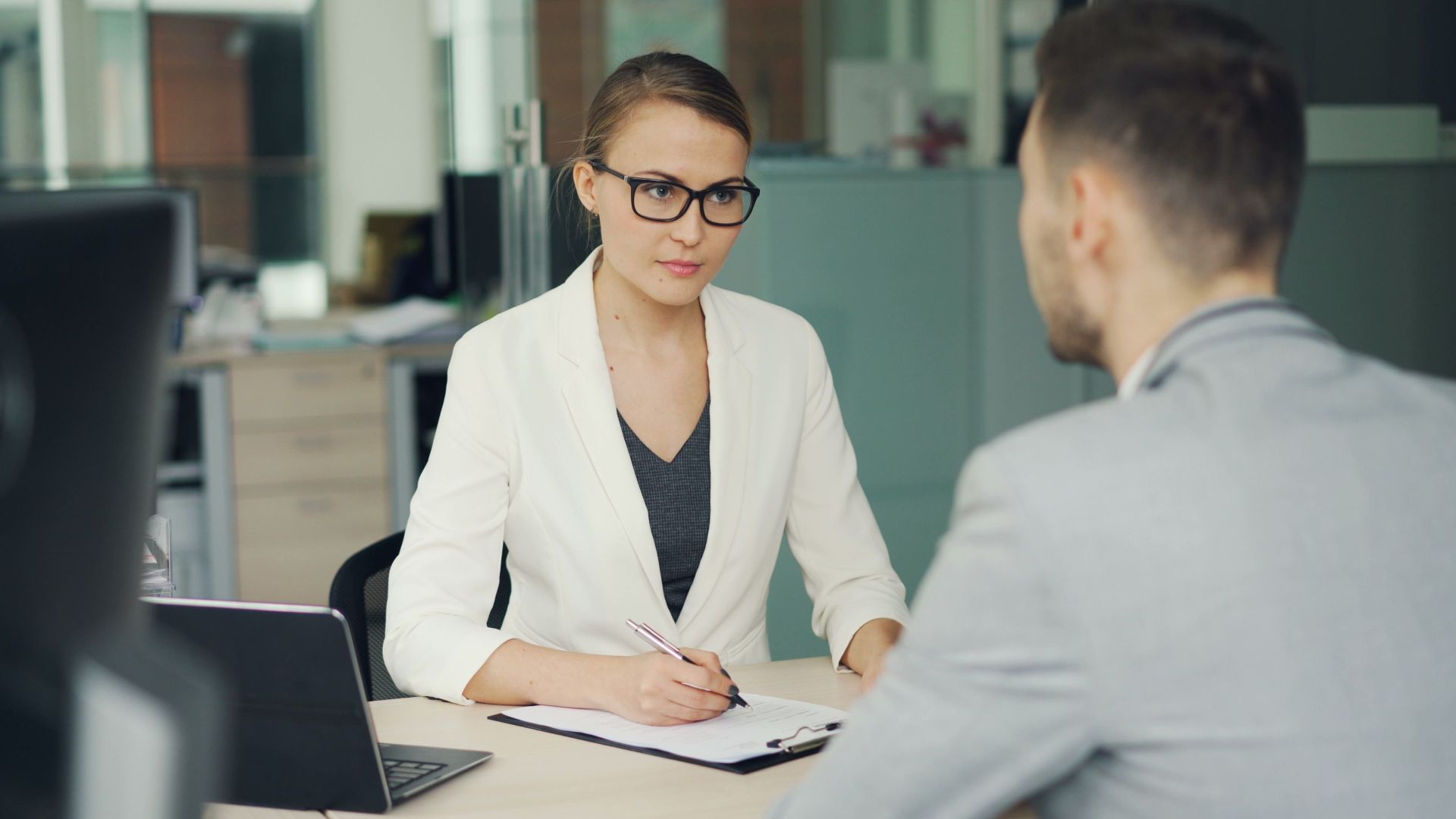 Two professionals in a serious business meeting at a modern office setting.