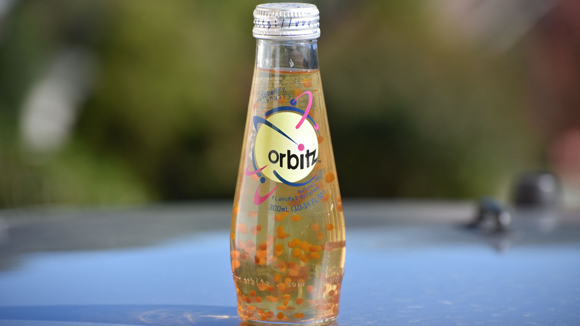 An unopened bottle of Orbitz sitting outside