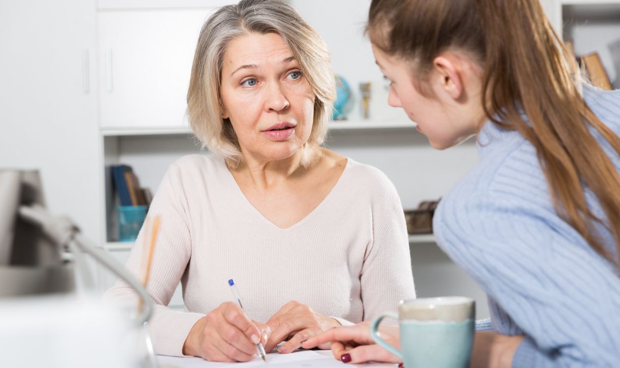 Woman and adult daughter fill out paperwork