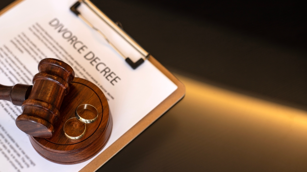 Divorce decree, gavel and wedding rings