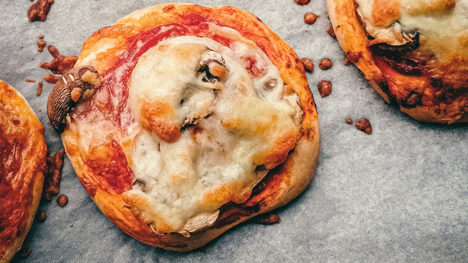 brown and white pizza on gray textile