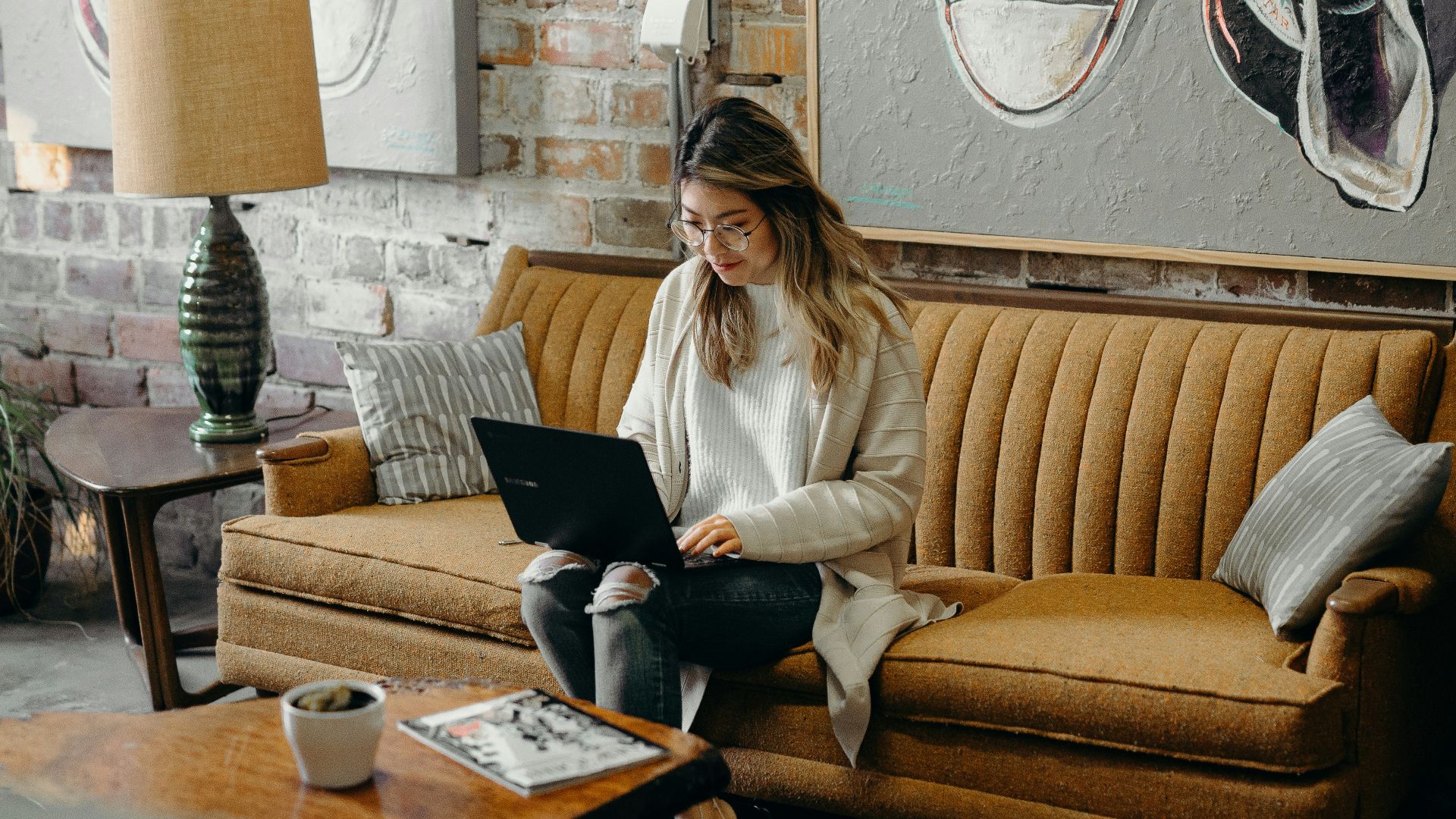 woman using laptop while sitting on chair