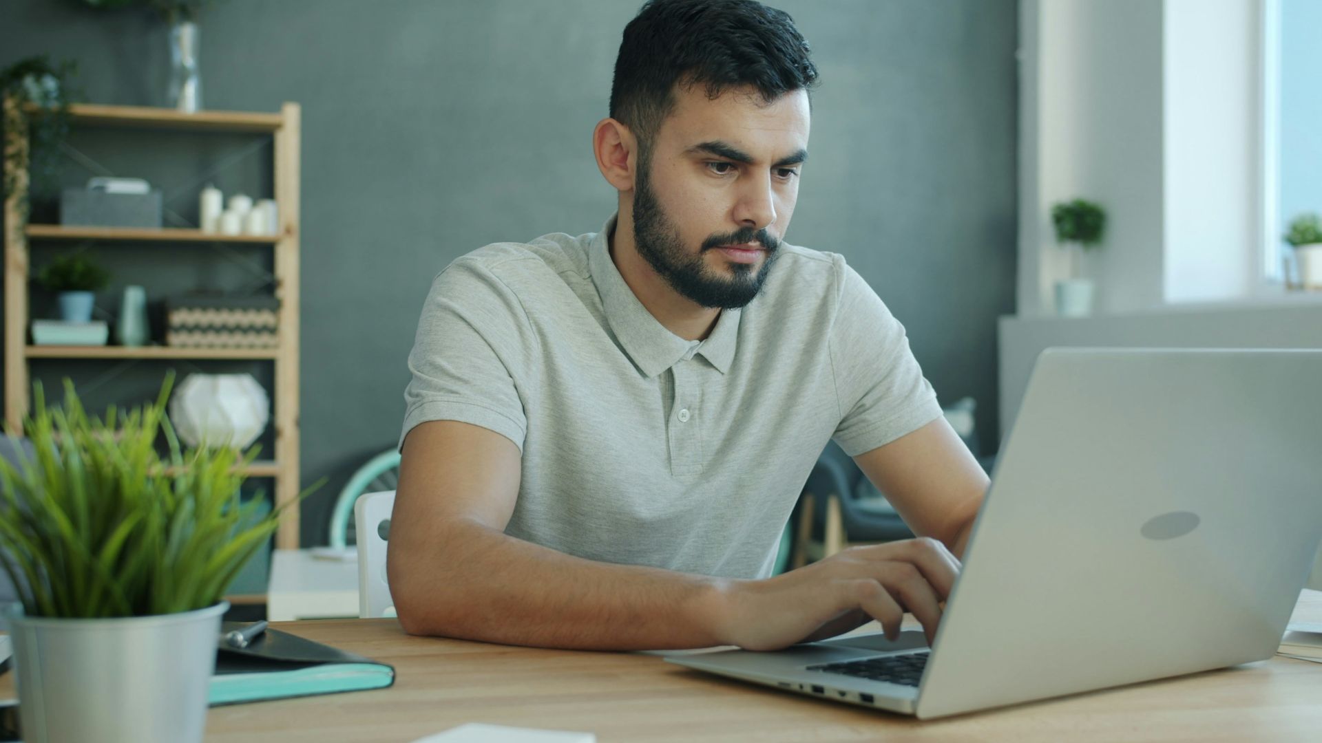Man typing on a laptop at a desk