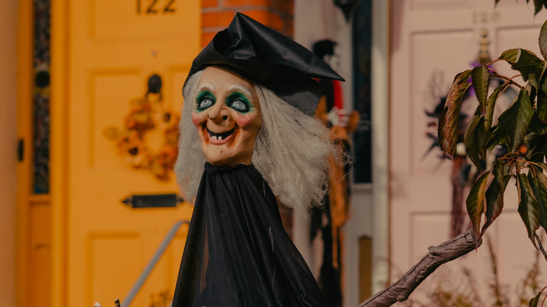 A statue of a witch in front of a house