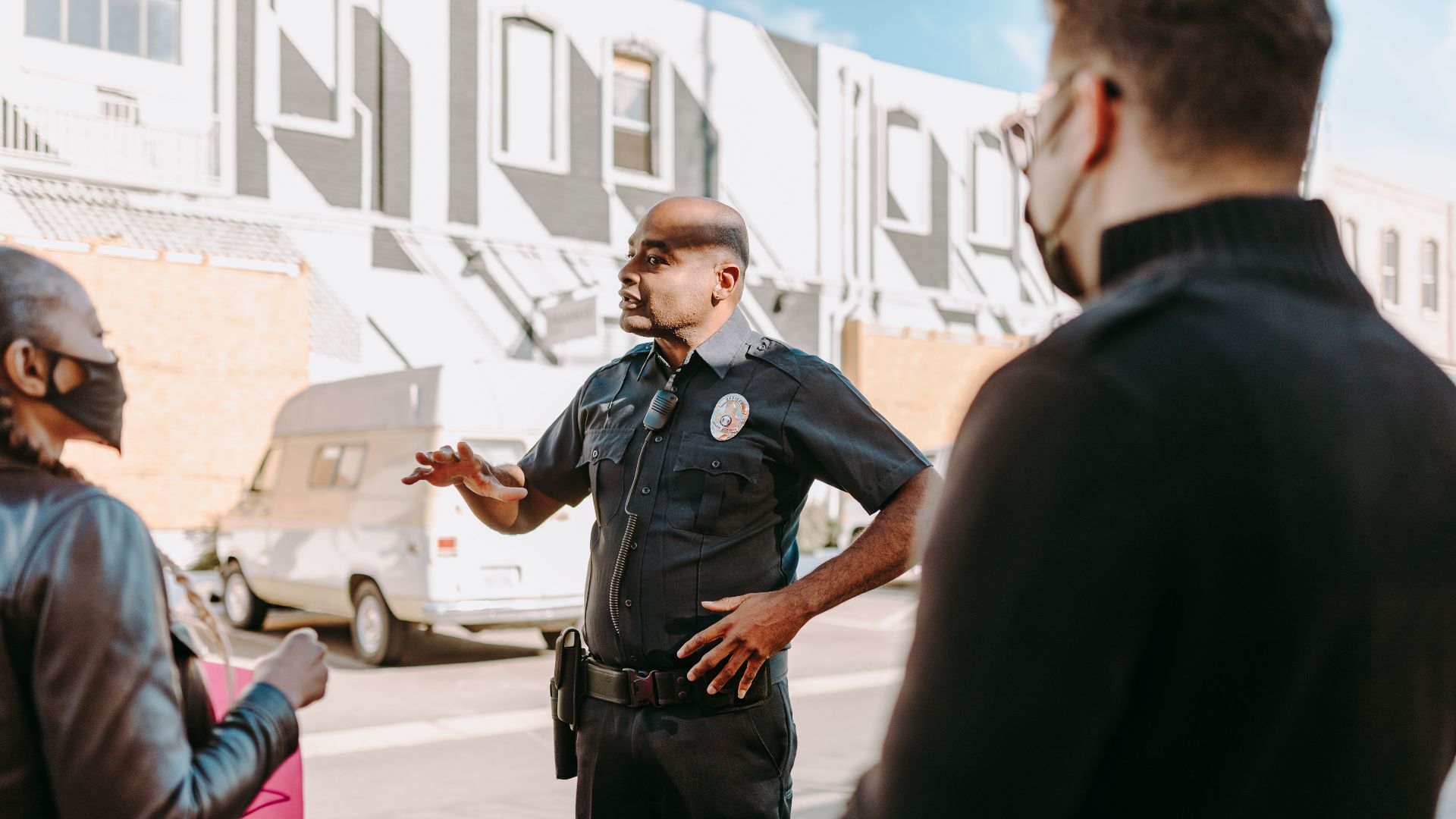 A police officer interacting with civilians during a peaceful protest in an urban setting.