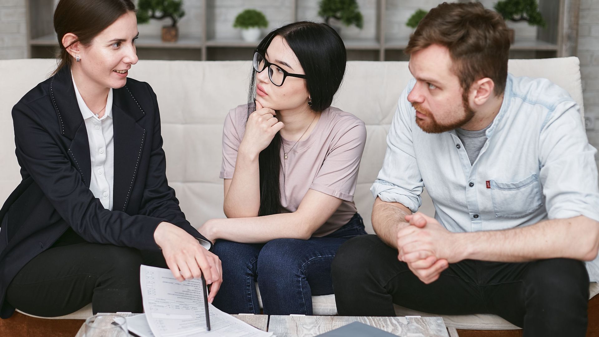 Three adults discussing business inside, focused on cooperation and strategy.
