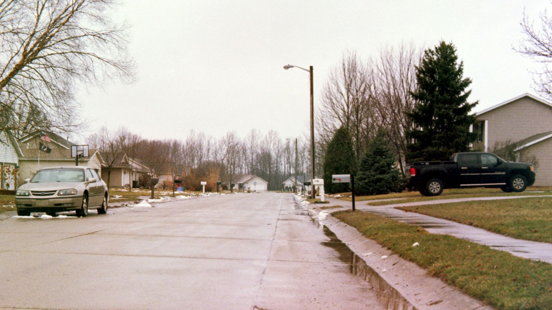 gray Chevrolet sedan parked near empty road
