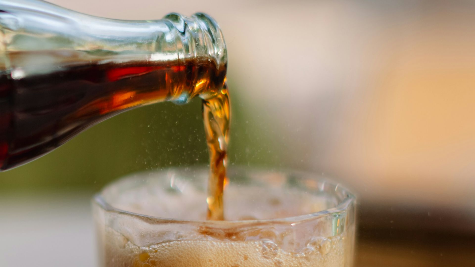 a person pouring a beverage into a glass