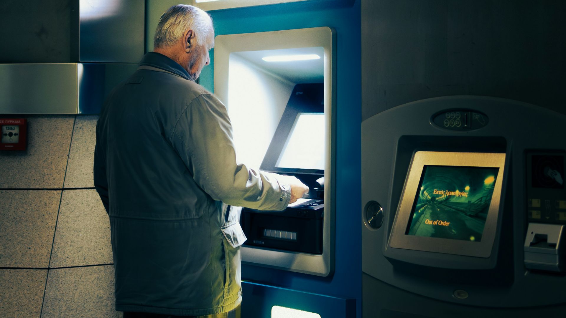 A man standing in front of a atm machine