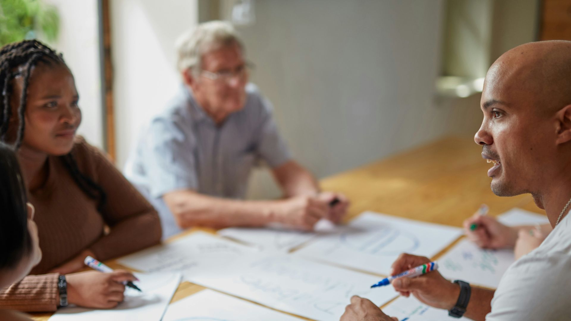 People are collaborating on papers at a table