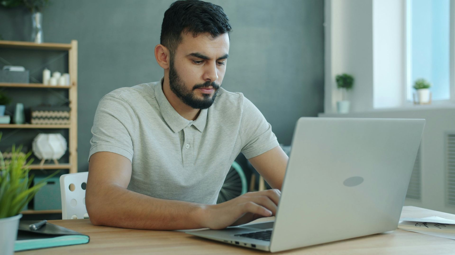 Man typing on a laptop at a desk