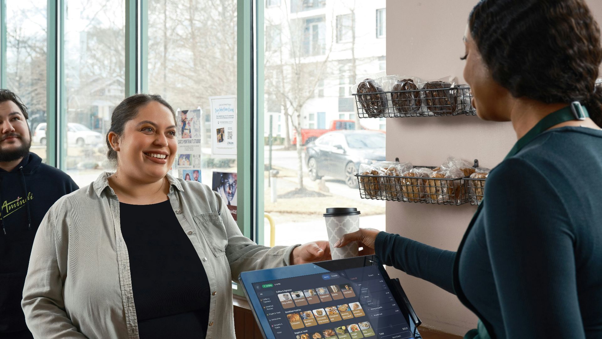 Barista hands coffee to smiling customer at counter