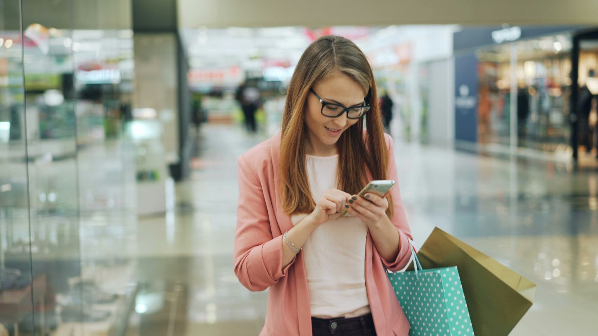 Woman using phone while shopping with bags